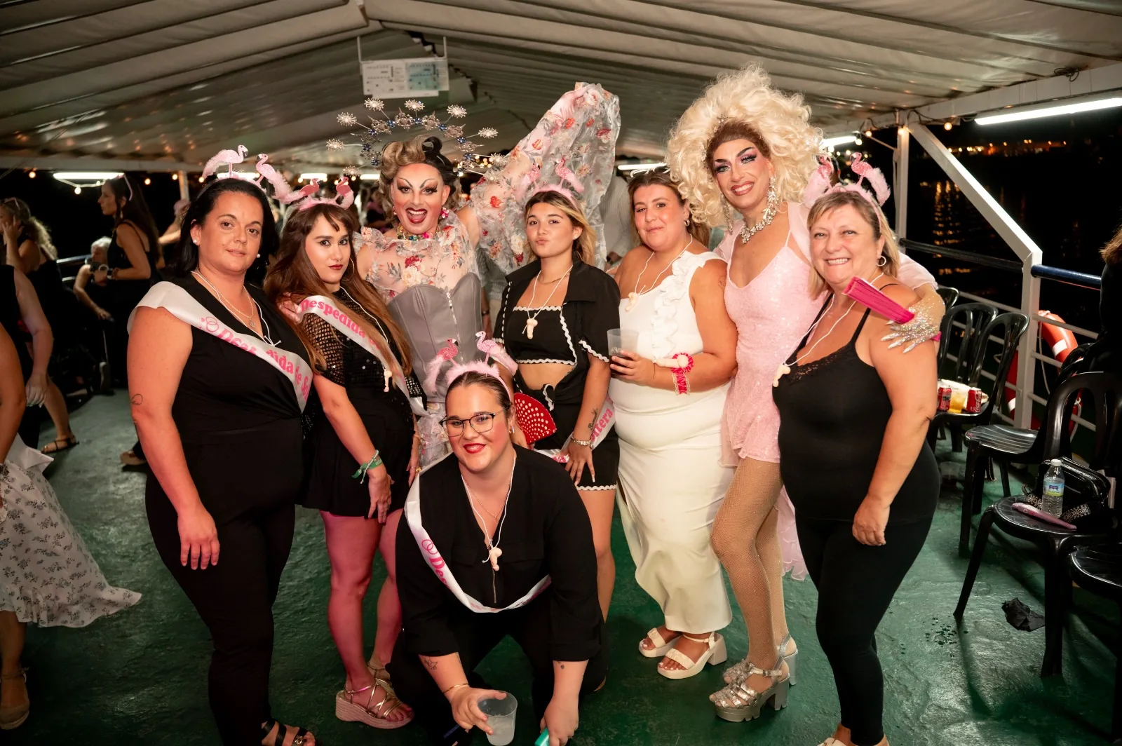Despedida de soltera con bandas y diademas posando con las drag queens a bordo en Sevilla